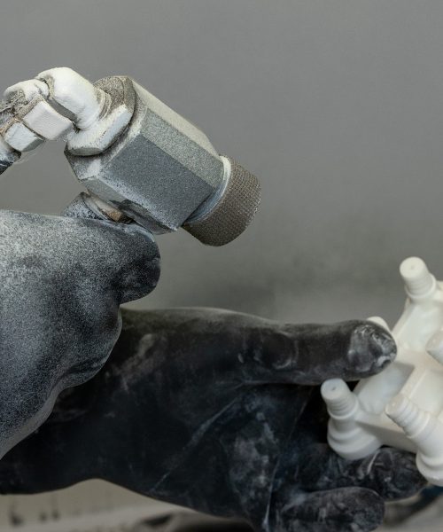 Hand mit düse zum Glasperlenstrahlen und lasergesinterten 3D-Druck Bauteil